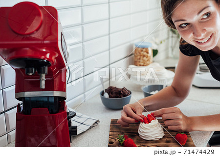 Beautiful woman pastry chef makes sweet cakes in kitchen Beautiful woman pastry chef makes sweet cakes in kitchen 71474429