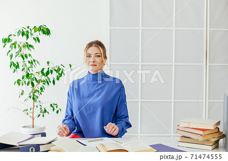 woman in business suit at work in office at a desk with books and documents accountant 71474555
