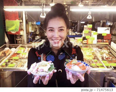 woman showing salmon sashimi most popular delicious food in street food tsukiji fish market, Japan woman showing salmon sashimi most popular delicious food in street food tsukiji fish market, Japan 71475613