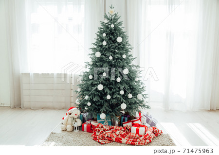 The interior of the white room with a blue Christmas tree with gifts for the new year decor winter postcard The interior of the white room with a blue Christmas tree with gifts for the new year decor winter postcard 71475963