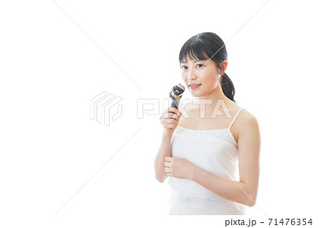 髭剃りを使う若い女性の写真素材