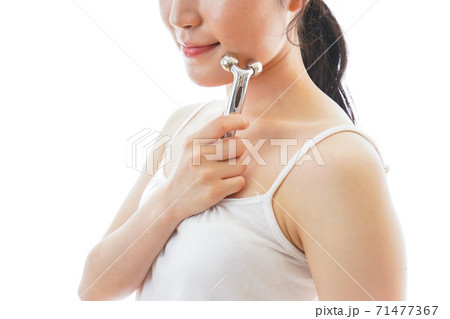 かっさで肌をマッサージをする若い女性 71477367