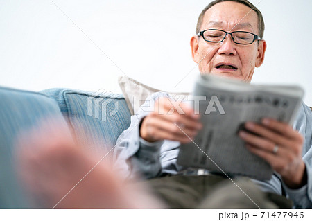新聞を読むシニア男性 71477946