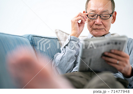 新聞を読むシニア男性 71477948
