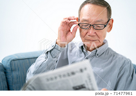 新聞を読むシニア男性 71477961