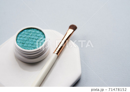 Green eyeshadow and makeup brush on white stand isolated background Green eyeshadow and makeup brush on white stand isolated background 71478152