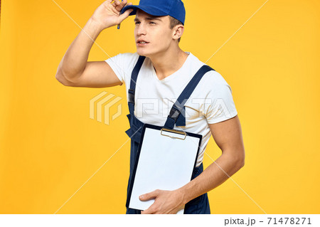 Man in working uniform documents rendering of services delivery service yellow background 71478271