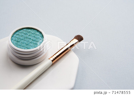 Green eyeshadow and makeup brush on white stand isolated background Green eyeshadow and makeup brush on white stand isolated background 71478555
