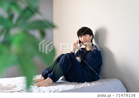 ベットルームで通話をする男性 71479138