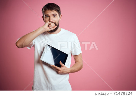 Man advertises a tablet on a pink background codes Space cropped view of emotions white t-shirt model new technologies Man advertises a tablet on a pink background codes Space cropped view of emotions white t-shirt model new technologies 71479224