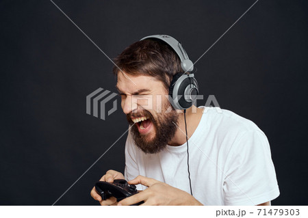 man in headphones with gamepad fun entertainment games lifestyle dark background man in headphones with gamepad fun entertainment games lifestyle dark background 71479303