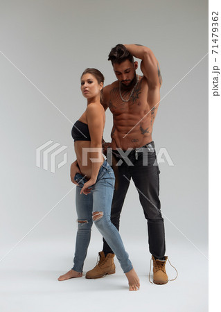 Woman hugging muscular man from behind 71479362