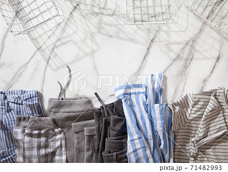 Group of organic cotton pyjamas set on white marble table is ready for folding and placing into white steel wire mesh baskets. 71482993