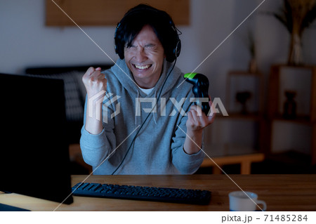 夜中オンラインゲームに熱狂する若い男性 夜中オンラインゲームに熱狂する若い男性 71485284