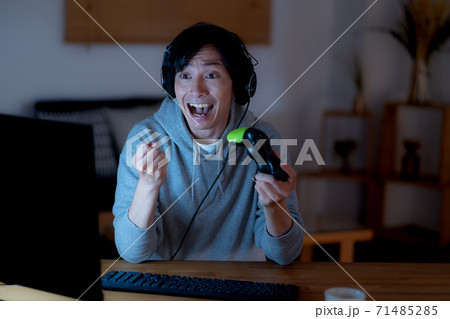 夜中オンラインゲームに熱狂する若い男性 夜中オンラインゲームに熱狂する若い男性 71485285