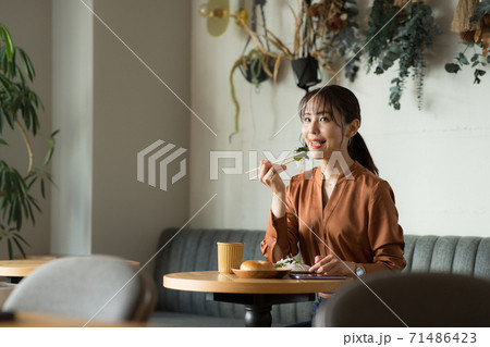 カフェで食事するかわいい女性 カフェで食事するかわいい女性 71486423