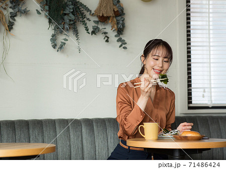 カフェで食事するかわいい女性 カフェで食事するかわいい女性 71486424