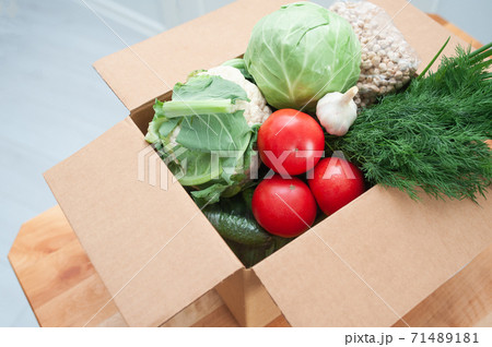 Contactless product delivery by the door. Food donation package vegetables to help the sick or poor. Donat box with foodstuffs Contactless product delivery by the door. Food donation package vegetables to help the sick or poor. Donat box with foodstuffs 71489181