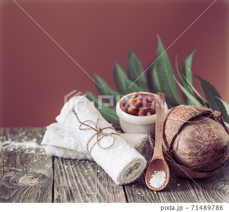 Spa and wellness setting with flowers and towels. Bright composition on brown background with tropical flowers. Dayspa nature products with coconut 71489786