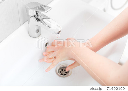 washing femle hands in a ceramic washbasin with a chrome tap, the bacteria of the covid-19 virus are washed off, close up faceless. washing femle hands in a ceramic washbasin with a chrome tap, the bacteria of the covid-19 virus are washed off, close up faceless. 71490100