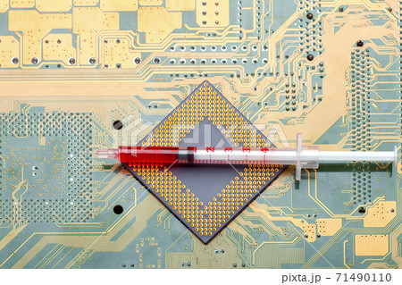 Neural network technology and artificial intelligence implantation, microprocessor CPU with contact legs lies on silicone printed circuit board with syringe and needle top view. Neural network technology and artificial intelligence implantation, microprocessor CPU with contact legs lies on silicone printed circuit board with syringe and needle top view. 71490110