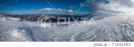 Snow covered mountain slope in last evening sunlight. Magnificent windy dusk on tops above picturesque alpine ski resort, Dragobrat, Ukraine, Carpathian Mountains. 71491485