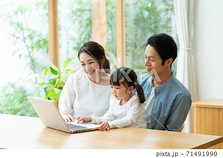 ノートパソコンを使って勉強する女の子とそれを見守るママとパパ 71491990