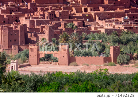 Daytime close up shot of Ksar de Ait Ben Haddou, with its abobe houses, surrounded by palm trees. Morocco. Daytime close up shot of Ksar de Ait Ben Haddou, with its abobe houses, surrounded by palm trees. Morocco. 71492328