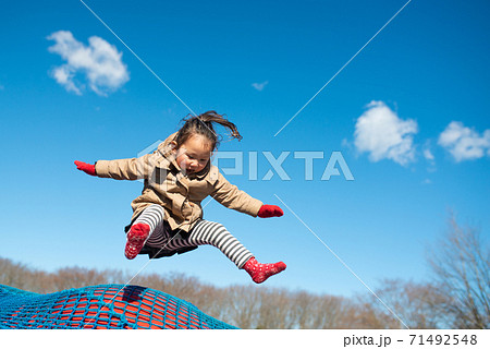 冬の公園でトランポリンをする女の子 71492548