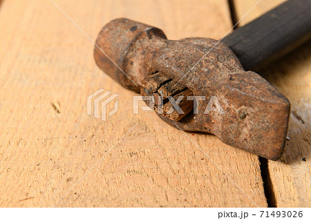 Old vintage hammer closeup on a wooden background, household hand tools 71493026