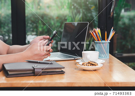 A man in casual wear using phone and working at home office. A man in casual wear using phone and working at home office. 71493363