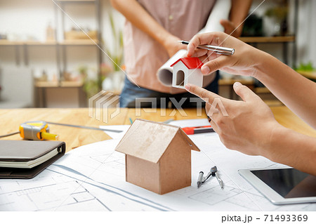 Confident team of architect working together in a office.Then discussing about new startup project on desk. Architect discuss with engineer about project in office, architectural concept Confident team of architect working together in a office.Then discussing about new startup project on desk. Architect discuss with engineer about project in office, architectural concept 71493369