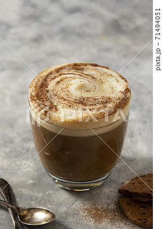 Glass of coffee drink with whipped milk, latte hot drink on gray background. 71494051