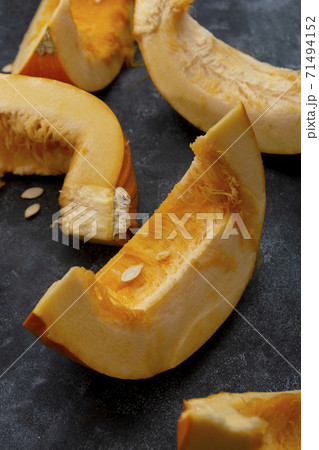 Pumpkin slices isolated on dark background, fall food. Pumpkin slices isolated on dark background, fall food. 71494152