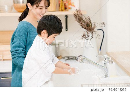 母親と一緒に手洗いする男の子 71494365