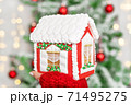 christmas gingerbread house on the hand with christmas tree bokeh 71495275