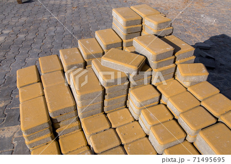 New yellow paving slabs piled in a pile one on top of another on a sunny day, close up. 71495695