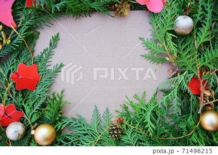 Fir branches, decorated with Christmas decorations lie on a cardboard background with copy space 71496215