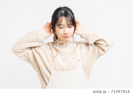 聞き耳をたてる若い女性 聞き耳をたてる若い女性 71497818