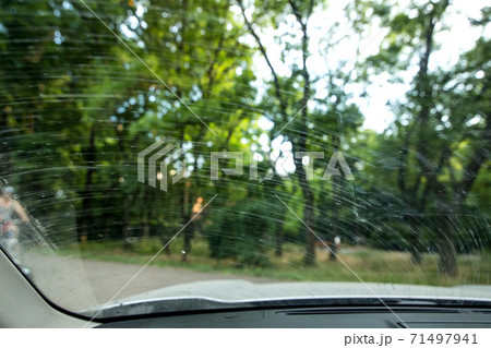 windshield in dirty stains from the swamp and dust smeared by the wipers, close up from inside the dirty car. 71497941