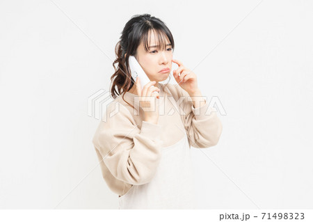 電話で話をしながら泣いている若い女性 電話で話をしながら泣いている若い女性 71498323