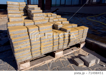 the yellow paving slabs folded in a pile one on top of another on a sunny day, side view close up. 71498451