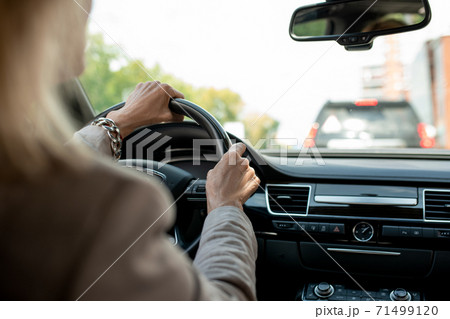 Hands of contemporary mature businesswoman holding by steer while driving 71499120