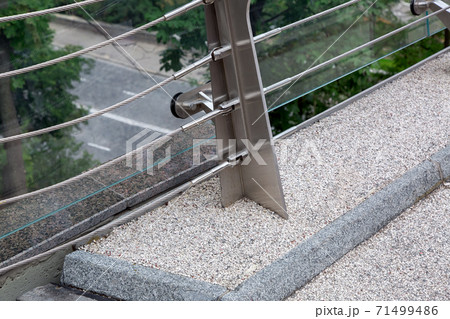 construction details of a glass bridge with steel mounts and a granite curb at the edge of the bridge close up. construction details of a glass bridge with steel mounts and a granite curb at the edge of the bridge close up. 71499486