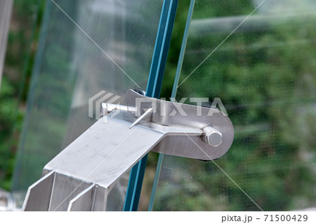Glass bridge angle of glass system connectors construction detail over green trees. Glass bridge angle of glass system connectors construction detail over green trees. 71500429