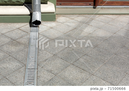 engineering structure downspout on facade building with drainage grate of gray stone granite sidewalk from square tiles on floor with copy space, closeup details city infrastructure, nobody. engineering structure downspout on facade building with drainage grate of gray stone granite sidewalk from square tiles on floor with copy space, closeup details city infrastructure, nobody. 71500666