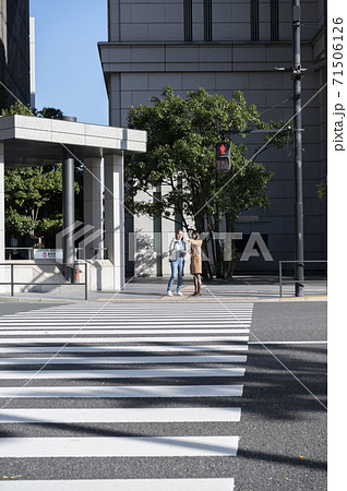 交差点で信号待ちしてる時に外国人女性に道を聞かれる日本人女性 71506126