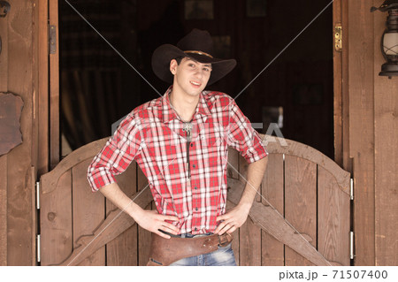Cowboy in hat standing near saloon entrance Cowboy in hat standing near saloon entrance 71507400