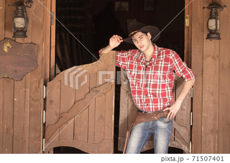 Cowboy in hat standing near saloon entrance 71507401