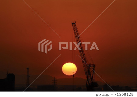 綺麗な丸い夕日と働く重機  沈みかけ 71509129